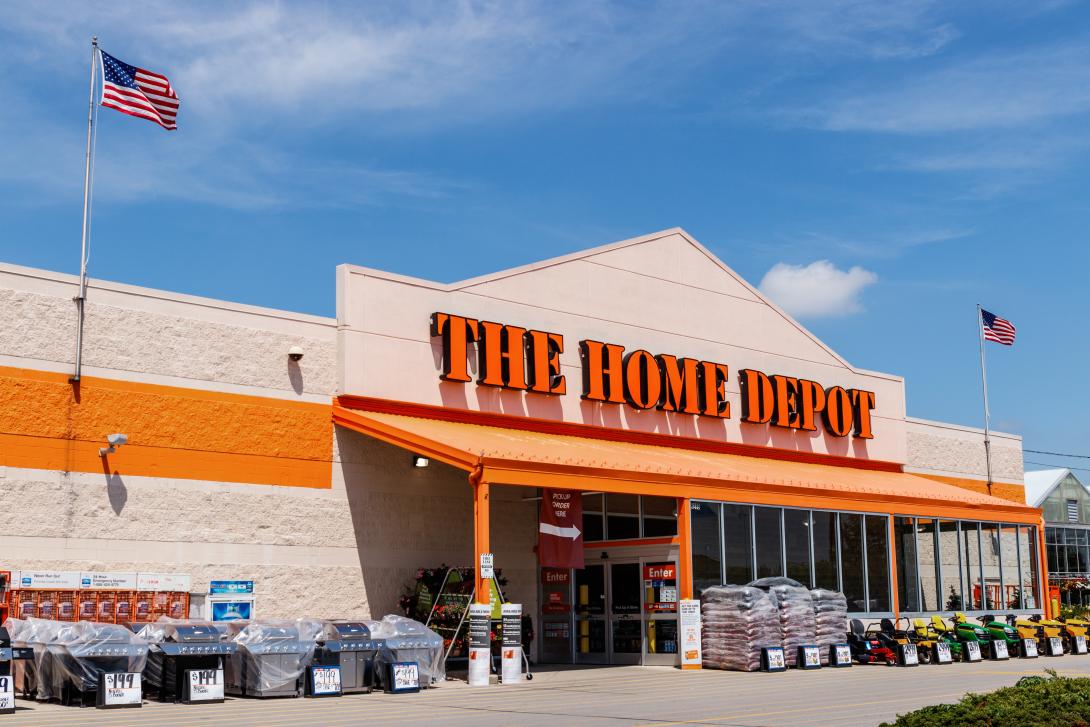 Exterior view of a Home Depot store showcasing an outdoor display of grills and garden supplies.